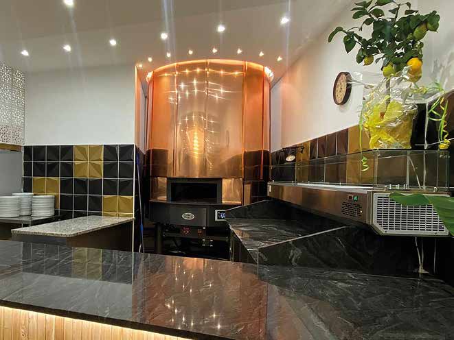 Copper MAM Torino pizza oven at the pass of an open restaurant kitchen